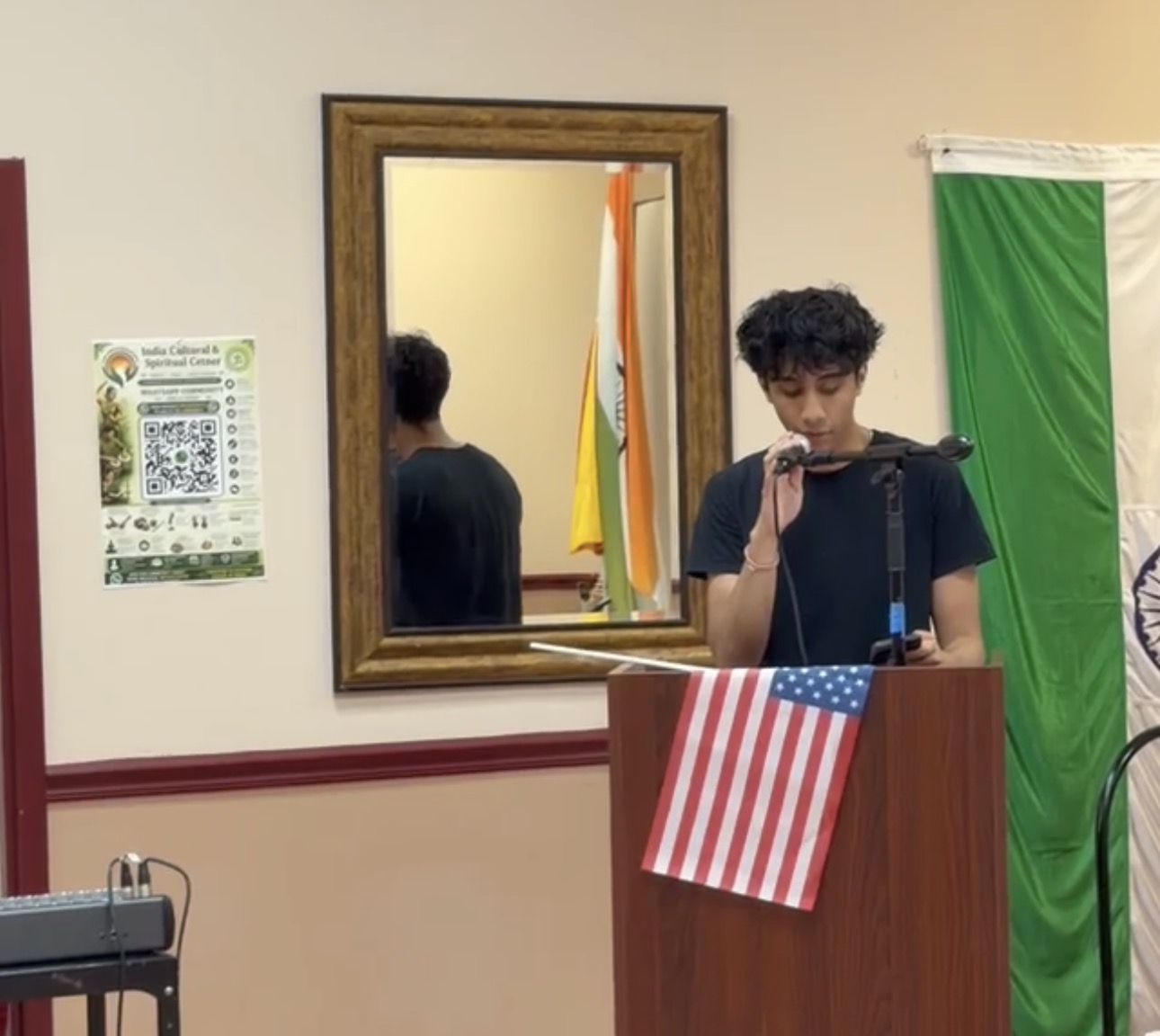 Student volunteer speaking at a podium during a community program